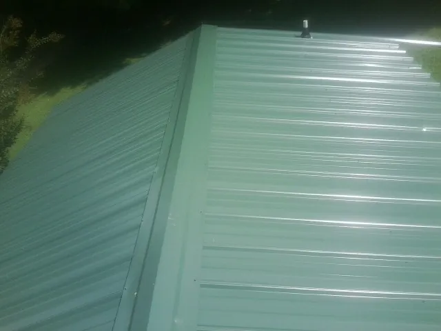 New green metal panels meeting at the ridge of a roof — Flat Roof Repair work by our crew in Descanso