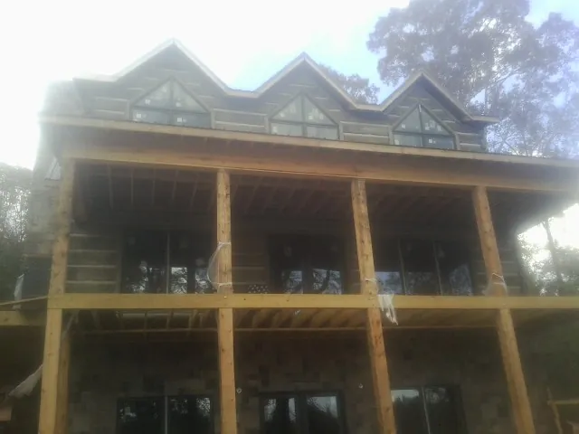 Dormers and porch framing on a large log home under construction — Roof Coating work by our crew in Descanso