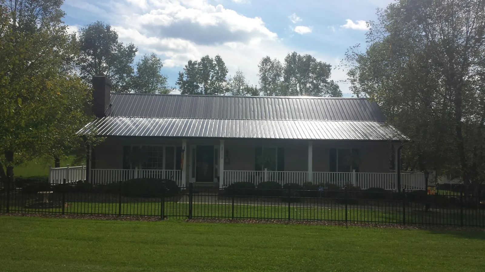 Gray metal roof on a brick ranch with a full width front porch — Gutter Guard Installation work by our crew in Descanso